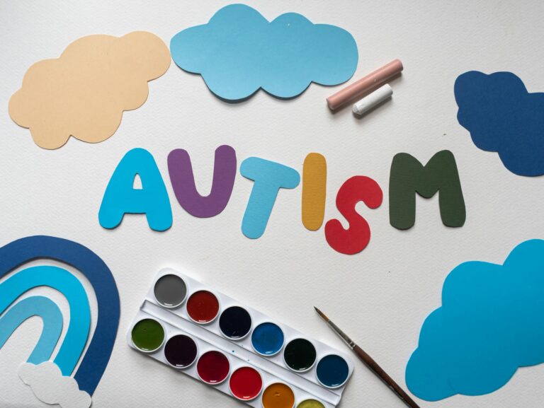 A vibrant autism awareness theme with watercolor paints and cutouts, featuring the word 'Autism'.