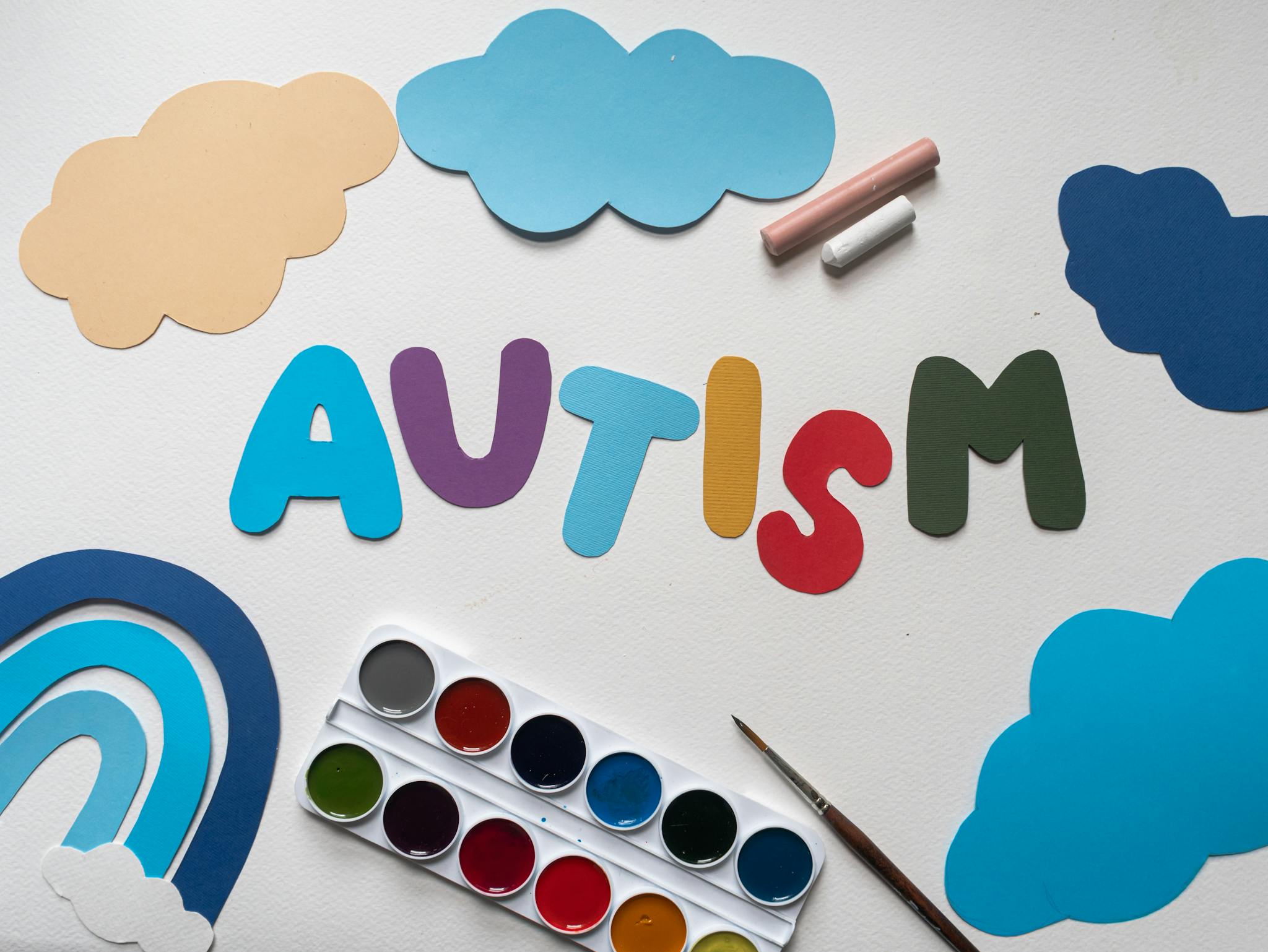 A vibrant autism awareness theme with watercolor paints and cutouts, featuring the word 'Autism'.