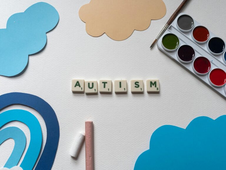 Creative art materials with autism awareness theme displayed in a flatlay style.