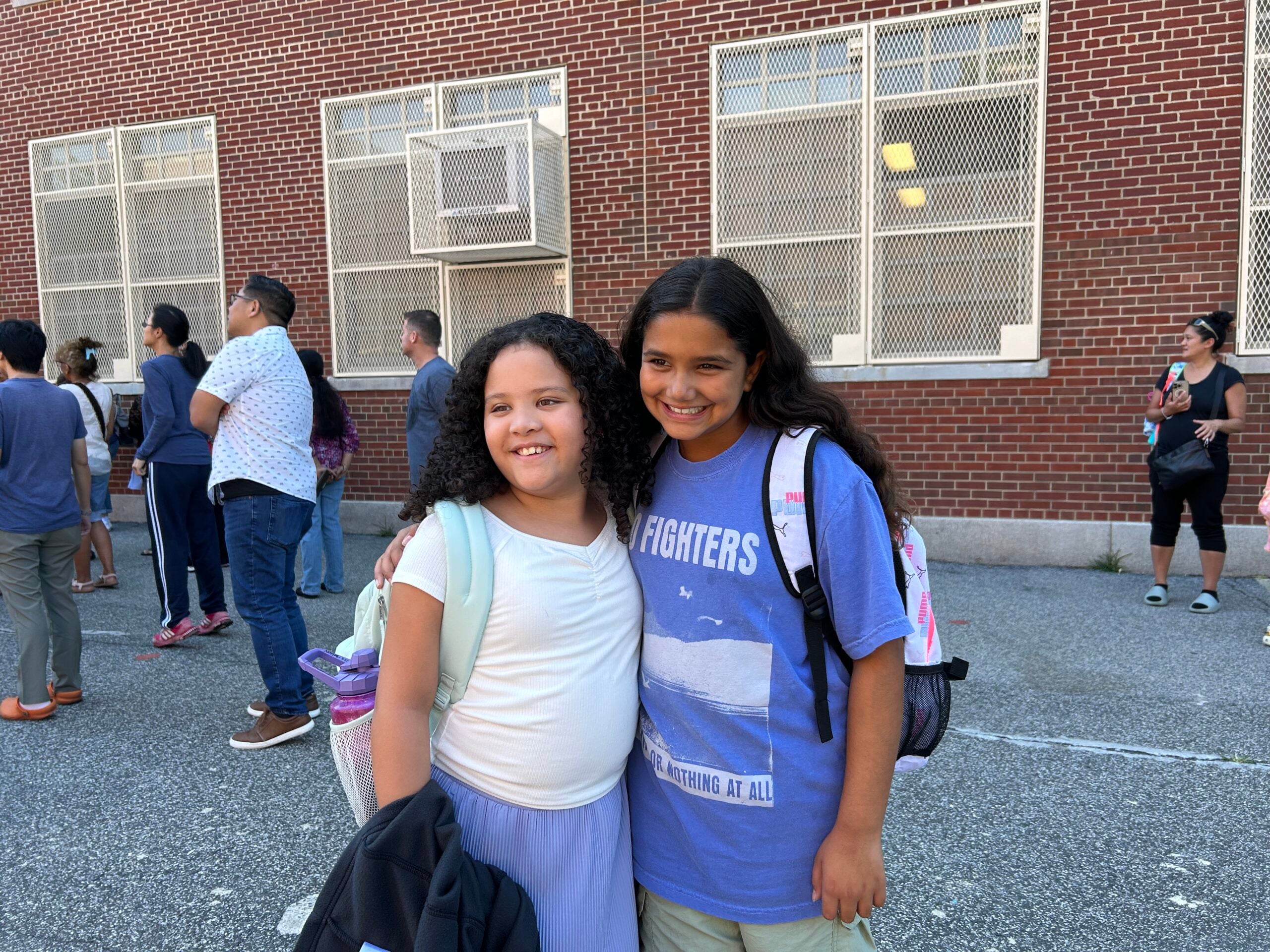 Our daughters smiling together outside school